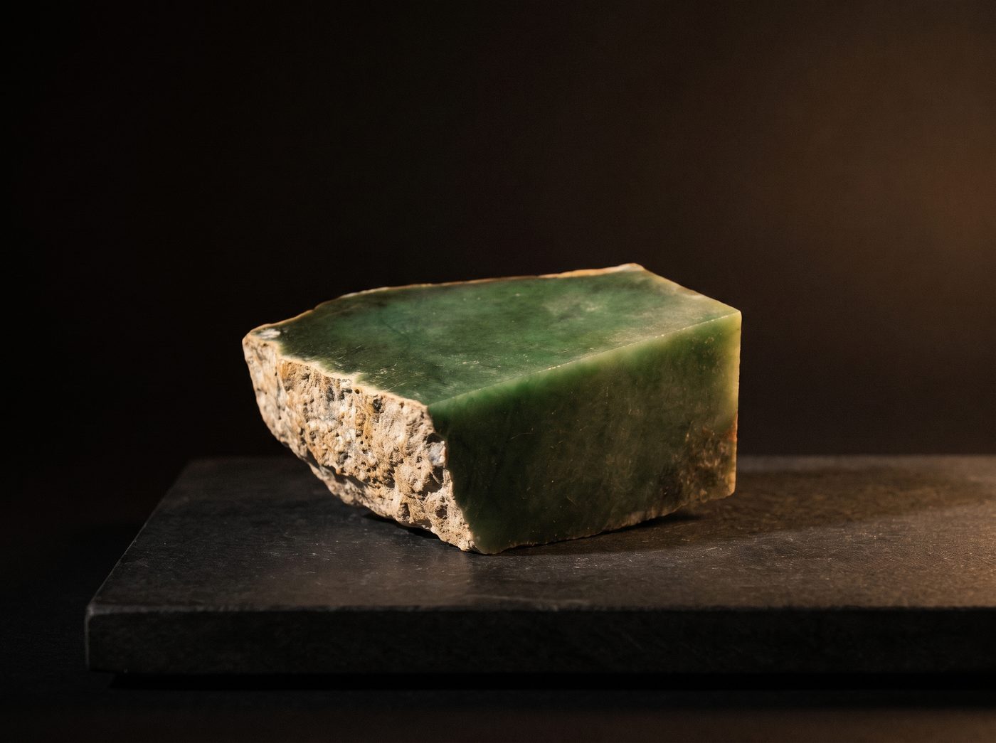 Green Jade rough specimen on dark stone