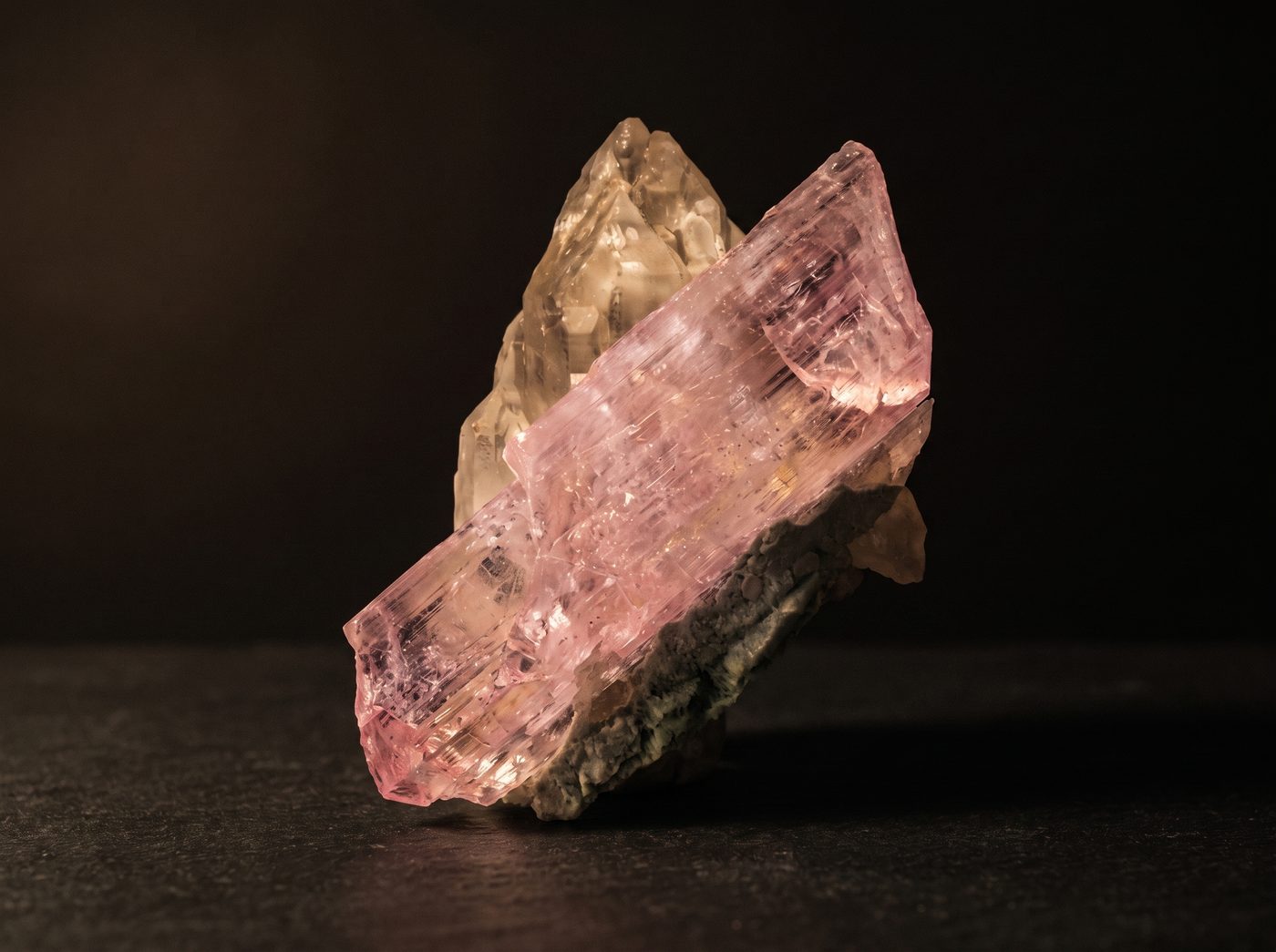 Kunzite rough specimen on dark stone