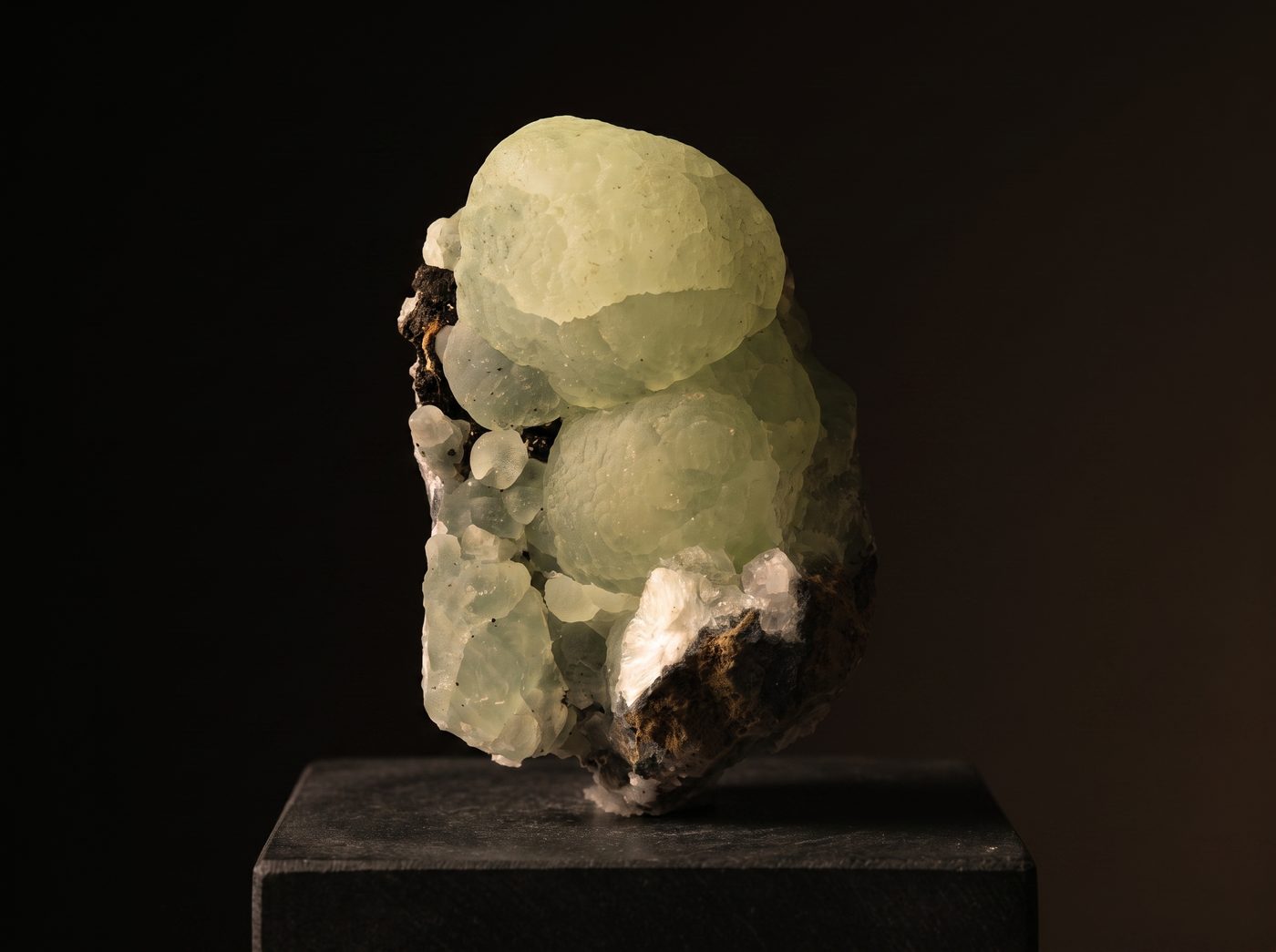 Prehnite rough specimen on dark stone