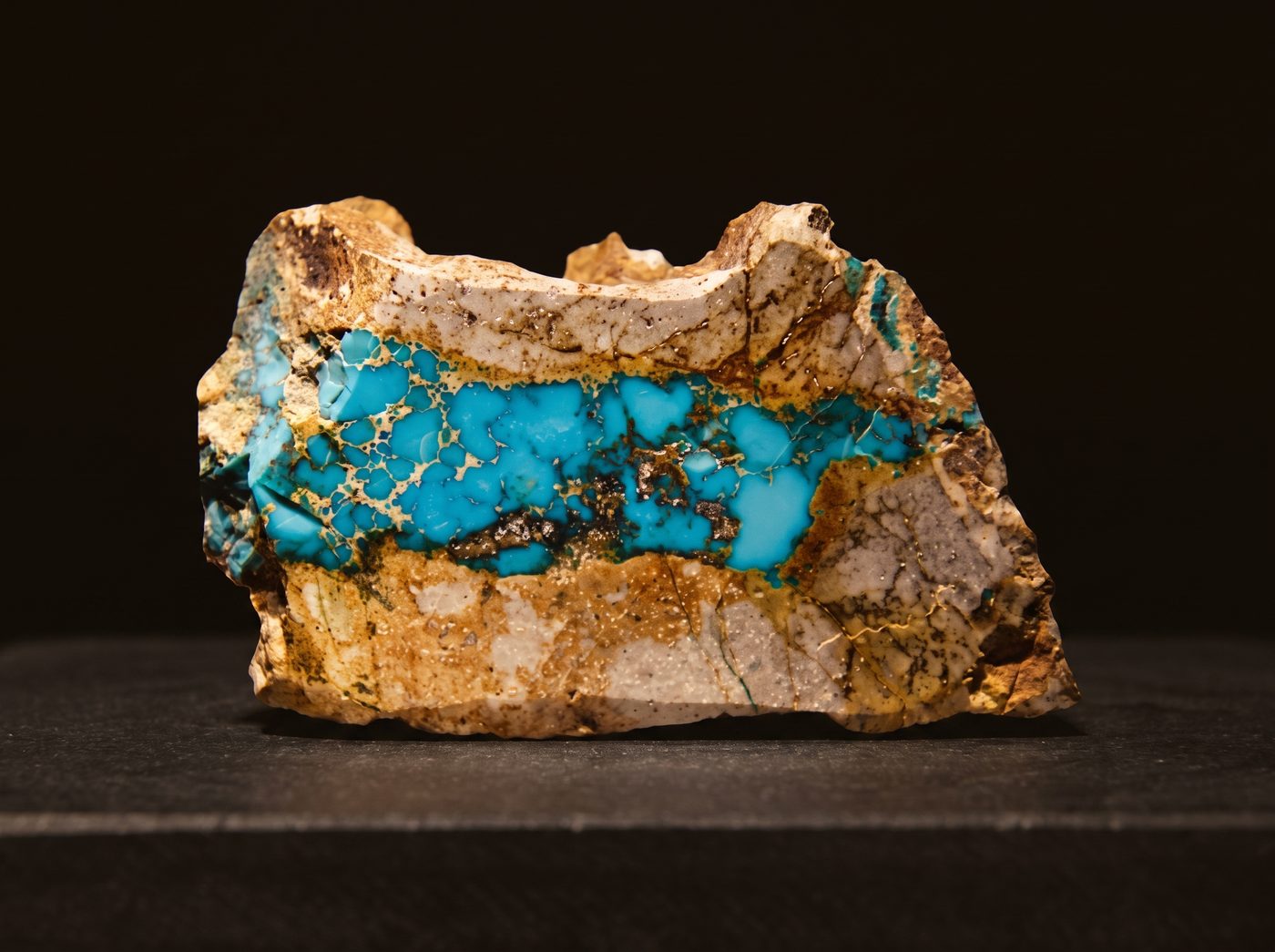 Turquoise rough specimen on dark stone